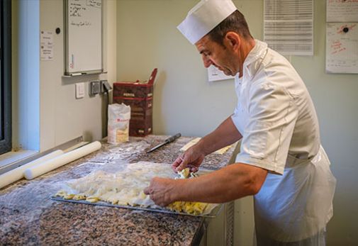Photographie d'un pâtissier réalisant des viennoiseries