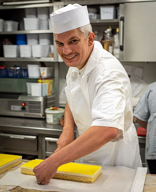 Photographie d'un pâtissier réalisant une pâtisserie
