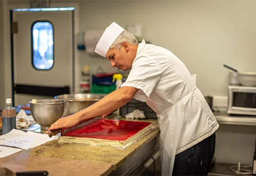 Photographie d'un pâtissier réalisant une pâtisserie